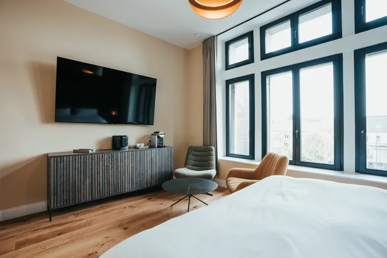 Chambre Prestige — télévision face au lit et hautes fenêtres à croisillons