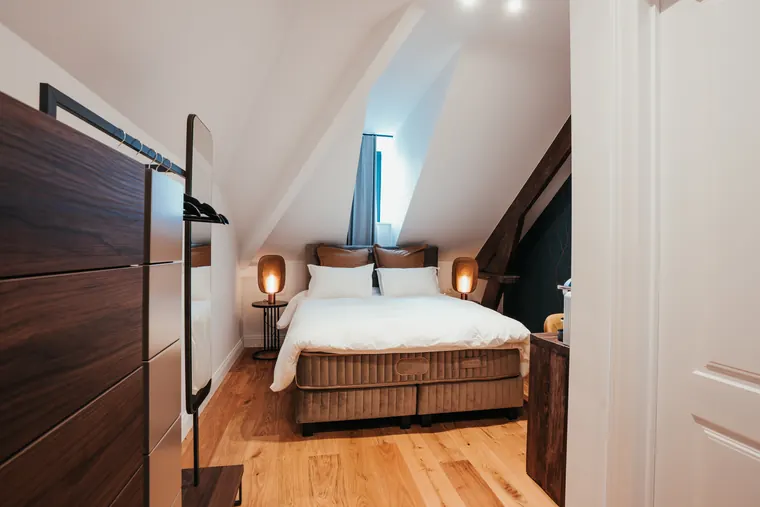 Chambre Tradition — poutre ancienne apparente et lit velours, ambiance de caractère